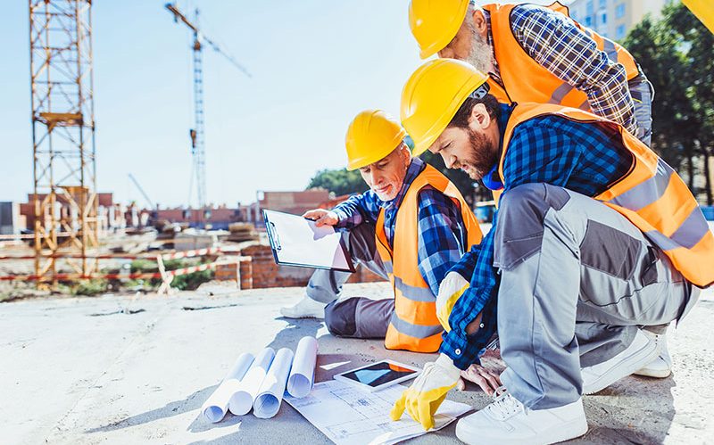 construction-workers-in-uniform-sitting-on-concret-PKB5Z24